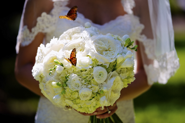 Lush white floral bridal bouquet with fluttering butterflies surrounding - wedding photo by top Atlanta-based wedding photographer Scott Hopkins Photography
